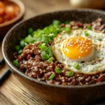 A delicious Korean Beef Bowl topped with sesame seeds and a fried egg.