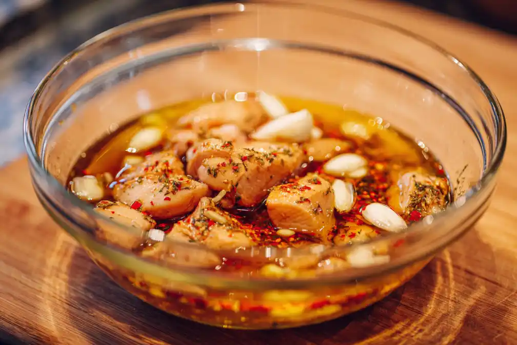 Chicken marinated with garlic, soy sauce, and spices in a bowl