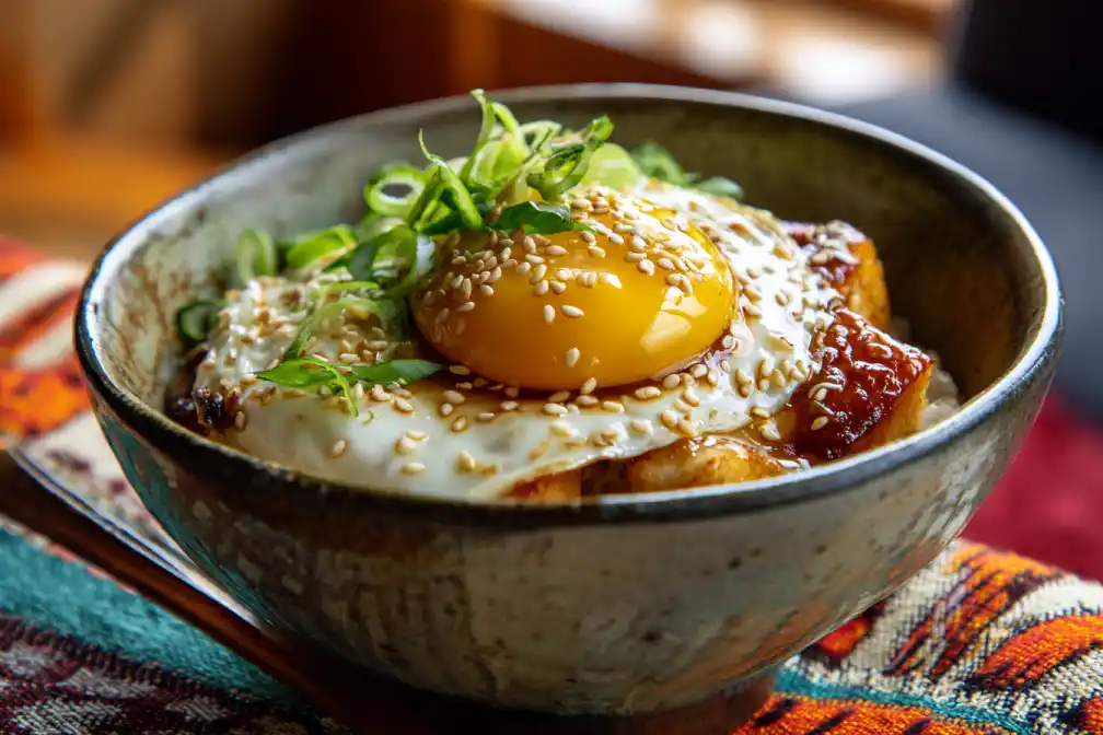 Gochujang tofu rice bowl garnished with sesame, scallions, and egg