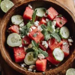 Featured bowl of watermelon and feta summer salad with mint and cucumber