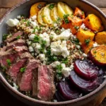 A vibrant beef and roasted root veggie power bowl in a white ceramic bowl.
