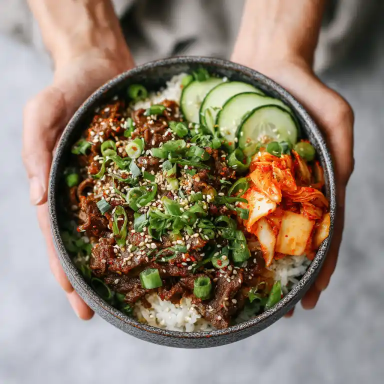 serving bulgogi beef bowl with kimchi and sesame